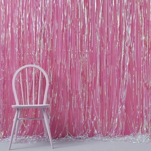 Pink wooden Windsor chair set against decorative iridescent pink fringe tinsel curtains