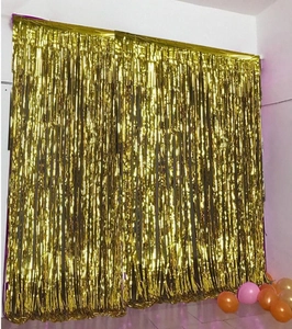 Golden foil fringe curtains for party backdrops with colorful balloons on floor