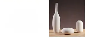 Detail von drei mattweißen Keramikvasen mit handgezeichneten horizontalen Strukturen