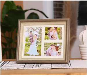 Detailed view of triple-opening wooden photo frame with ornate beige border on a table