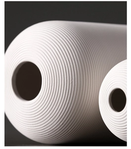 Detail van een matwitte keramische vaas met horizontale ribbels voor modern decor