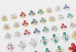 Macro view of crystal flower nail art charms with colorful rhinestones on metal base