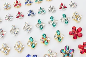 Macro view of colorful crystal flower nail art charms with gold and silver metal bases