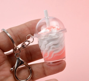 Détail d'un porte-clés mini thé aux perles rose avec crème et fermoir mousqueton argenté
