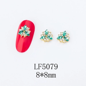 Detailed view of 8x8mm 3D flower nail charms with green rhinestones and alloy base