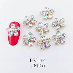 Macro view of 13x13mm gold metal flower nail charm with AB rhinestones on a red nail