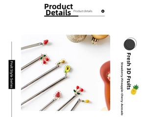 Detailed view of stainless steel spoons with strawberry and pineapple charms