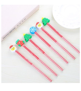 Detail view of 6 Christmas HB pencils with Santa and tree erasers on a wooden table