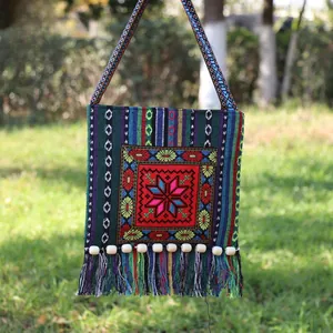 Detailed embroidery and colorful tassels on ethnic geometric woven crossbody bag