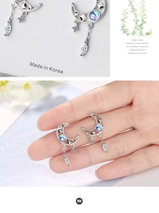 Close-up of silver moon tassel earrings with light blue gemstones and white zircons