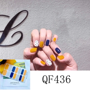 Macro detail of waterproof 3D nail stickers featuring yellow, navy, and polka dot designs