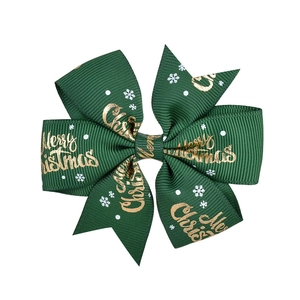 Macro detail of dark green ribbed ribbon bow with gold Merry Christmas print and white snowflakes