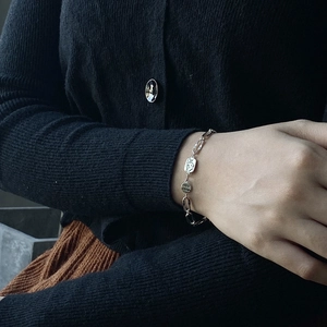 Elegant 925 sterling silver chain bracelet with round embossed pendants worn on wrist