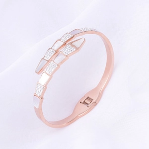 Macro shot of rose gold snake bracelet with white mother-of-pearl and crystal pavé detailing
