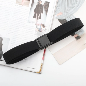 Detailed close-up of a black woven elastic belt with a matte black buckle on magazines
