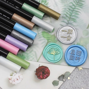 Metallic markers for wax seal coloring on decorative paper with floral accents