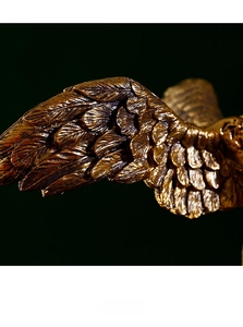 Macro view showing detailed wing textures on bronze Winged Victory resin sculpture
