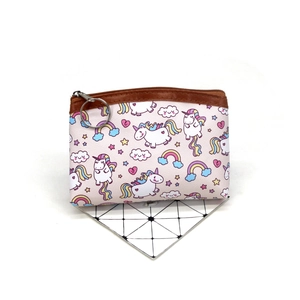 Close-up of unicorn coin purse featuring a round metal keychain and leather piping