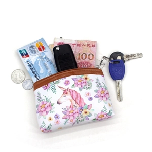 Compact unicorn coin purse with zipper holding bank cards, keys and cash