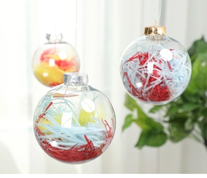 Close-up of clear Christmas balls filled with colorful paper strips and metal hangers