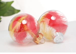 Close-up of clear plastic Christmas balls filled with red and yellow feathers