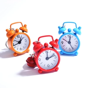Mini alarm clock keychains in orange, red, and blue with classic double bell design