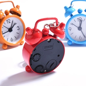 Rear view of mini quartz alarm clock keychains showing battery slots and setting knobs