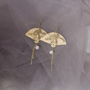 Golden Chinese fan earrings with white pearls and tassels on soft purple tulle fabric