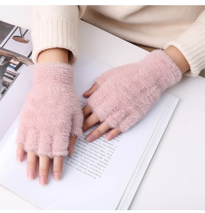 Gros plan de mitaines en peluche rose doux portées lors de la lecture d'un livre