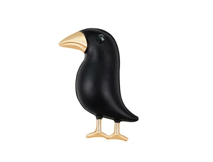 Close-up of black crow brooch with gold beak and gemstone eye detail on white backdrop