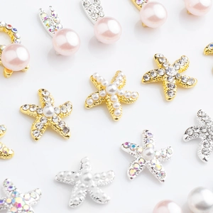 Macro detail of alloy starfish nail charms with pink pearls and shiny rhinestones