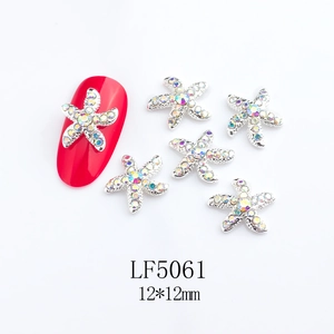 Starfish nail charm with silver base and rhinestones, size 12x12mm shown on red nail
