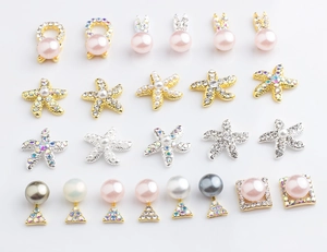 Detailed flat lay of assorted alloy nail charms with pearls and rhinestones