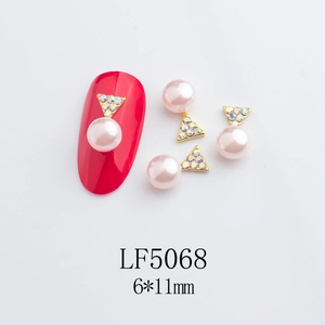 Detail of pink pearl star nail jewelry with gold base and rhinestones, size 6x11mm
