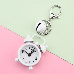 Close-up of a creative white alarm clock keychain with a matching bell and lobster clasp