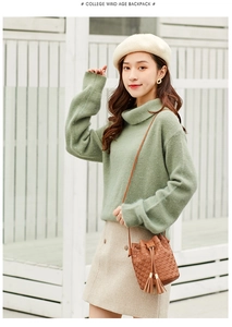 Détail d'un sac seau marron avec texture à pois et franges porté par un mannequin
