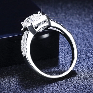 Macro view of 1ct round moissanite engagement ring with halo and pavé silver band