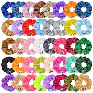 Matrix display of 40 solid color satin scrunchies in various vibrant silky shades