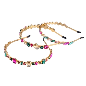 Three gold metal thin headbands with colorful rhinestones on a clean white background