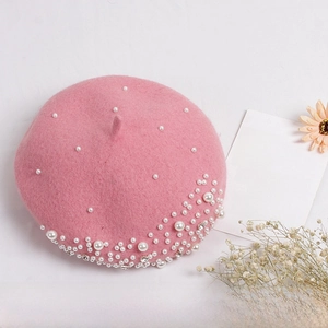 Close-up of pink wool beret for girls with scattered white pearls and rhinestone detail