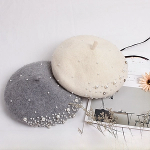 Detailed view of pearl and rhinestone embellishments on knitted wool blend berets