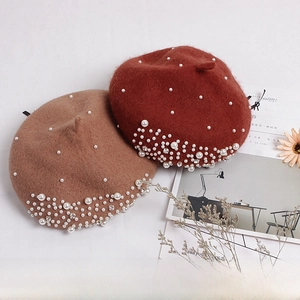 Detailed view of kids wool berets with pearls and rhinestones in tan and brick red