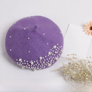 Detailed view of deep purple wool beret featuring clustered white pearls and rhinestones
