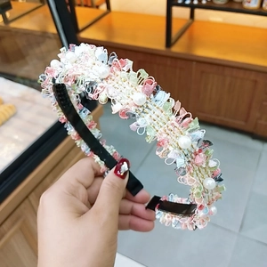 Detaillierte Nahaufnahme eines gestrickten Haarreifs mit bunter Spitze und Kunstperlen