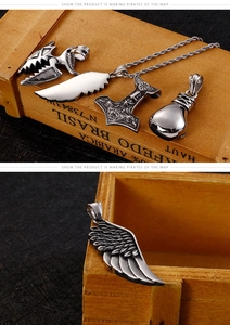 Detail of vintage Viking pendants featuring angel wings and eagle claws in a wooden box