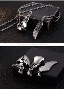 Macro shot of boxing glove and wing pendant necklace crafted in high-quality polished metal