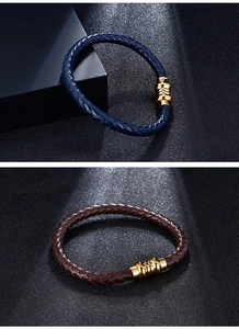 Detail of dark blue and brown braided leather bracelets with gold magnetic clasps