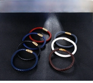 Detailed macro view of woven leather bracelets with 18K gold textured magnetic clasps