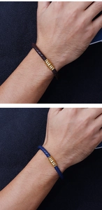 Detailed close-up of woven leather bracelets in brown and navy blue with gold accents