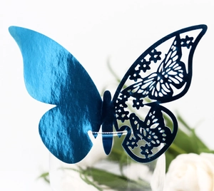Macro view of blue laser-cut paper butterfly cup card for wedding table decorations